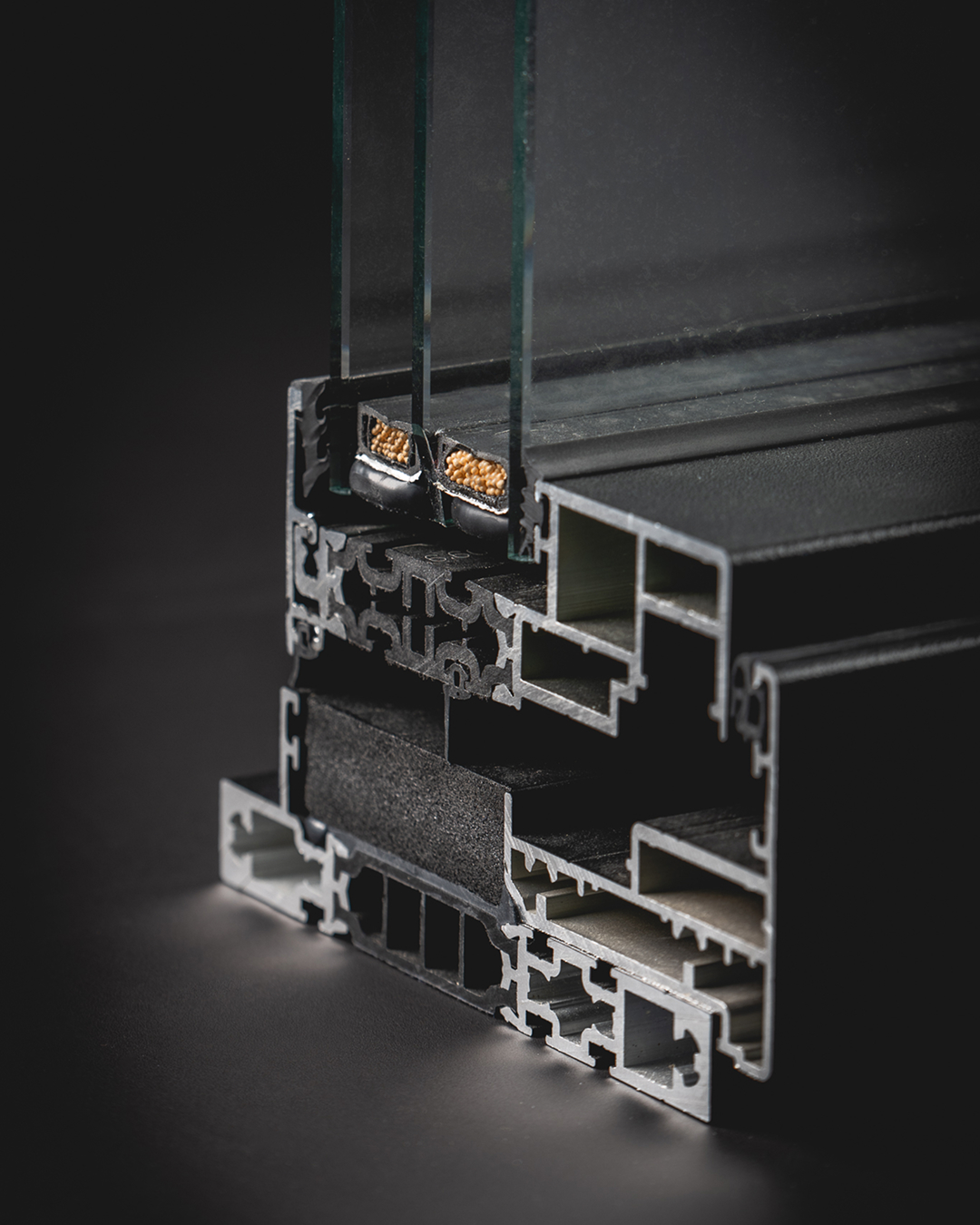 Tværsnit af aluminiumsprofil med termisk brud og integrerede isoleringszoner, som reducerer varmeledning gennem konstruktionen.